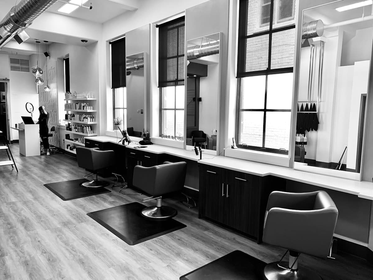 Interior de una peluquería unisex con sillones y espejos